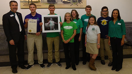 4-H officials and youth standing, governor proclaims National 4-H Week