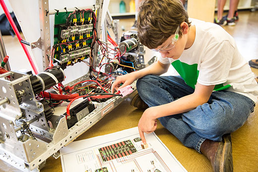 Boy studying instructions for 4-H electronics project