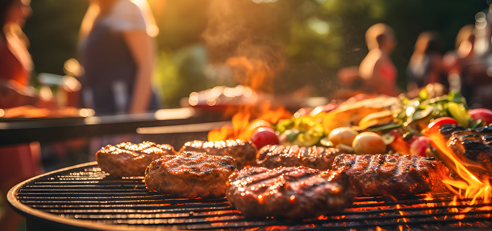 Closeup of barbecue grill, hamburgers and vegetables cooking Closeup of barbecue grill, hamburgers and vegetables cooking