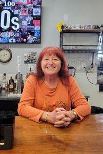 Woman sitting at a restaurant table, Deb Tudor