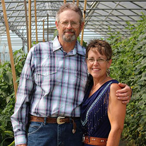 Don and Susan Rommelfanger, standing in greenhouse