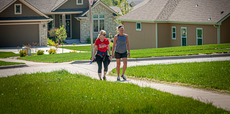 Two women walking together in a suburban neighborhood