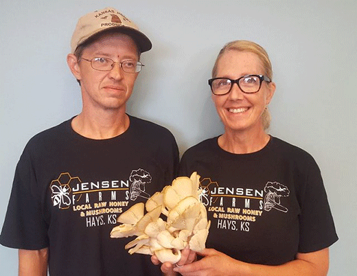 Two people standing with mushroom, Mike and Amy Jensen