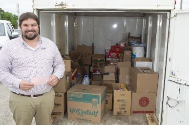 Man standing near trailer with boxes of food