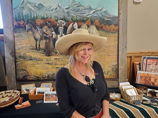 Woman wearing straw cowboy hat sitting in front of table