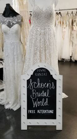 Bridal store sign with white wedding dresses in background