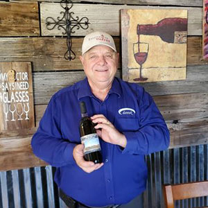 Man holding bottle of wine, Allen Schmidt