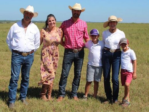 Six family members standing in farm field