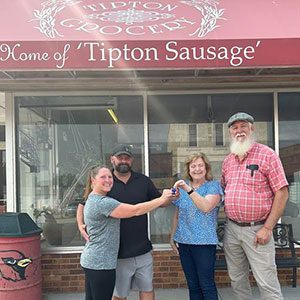 Four people standing in front of Tipton Grocery store