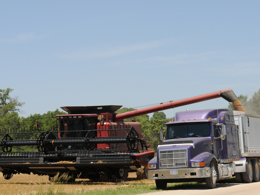 Harvester loading farm truck with grain