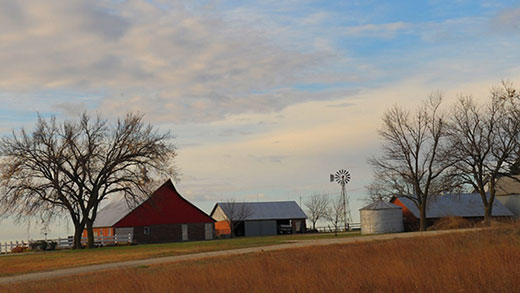 Kansas farm scene, red barn and buildings with white fence