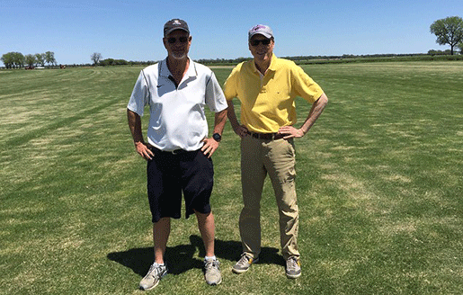 Two men standing on stretch of zoysia grass