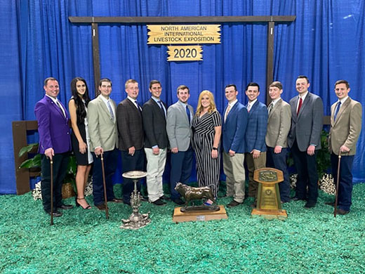 Twelve individuals standing with national championship trophies
