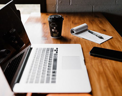 Laptop with notebook and pen on a desk