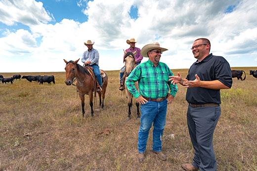 Four men with cowboy hats standing on open prairie