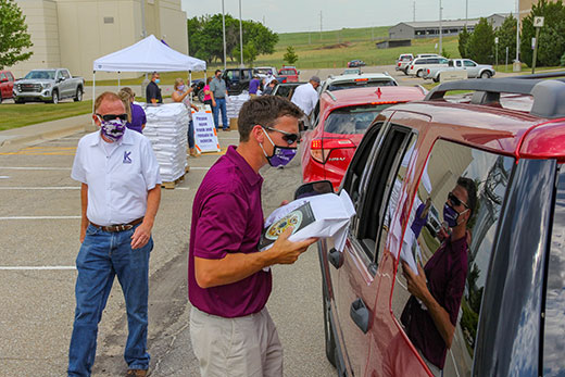Man wearing mask putting bag of flour in car Man wearing mask putting bag of flour in car
