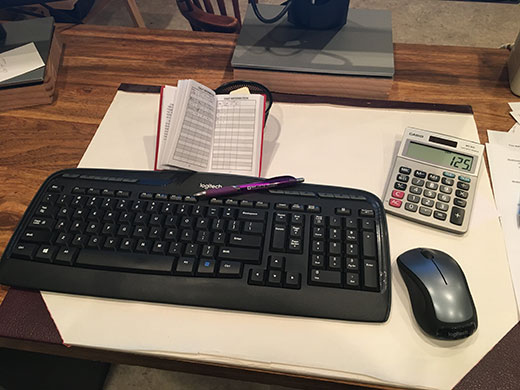 Office desk with keyboard, calculator and log