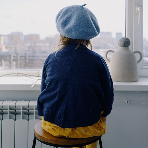 Small girl sitting on stool looking out window Small girl sitting on stool looking out window