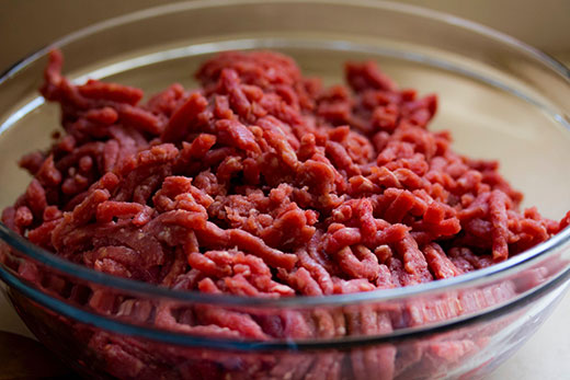 uncooked ground beef in a glass bowl