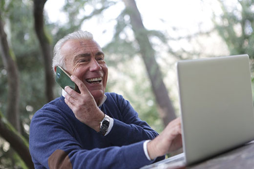 Man on computer and talking on phone