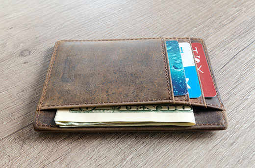 wallet with money and credit cards laying on a table