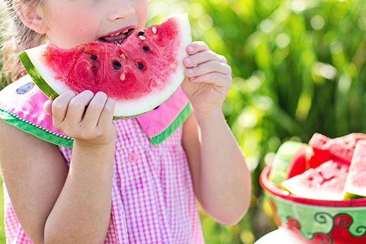 Young girl eating slice of watermelon