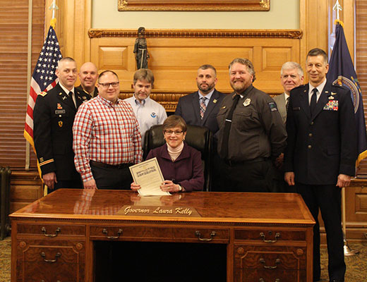 Eight people at governor's desk, wildfire awareness proclamation