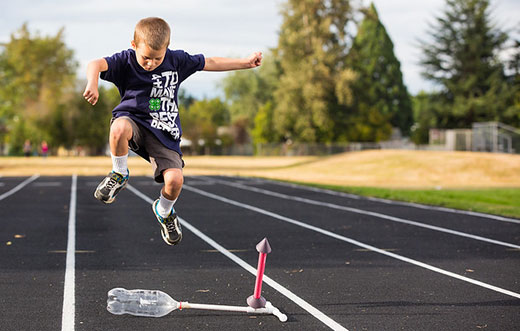 Boy stomping on plastic bottle to launch rocket