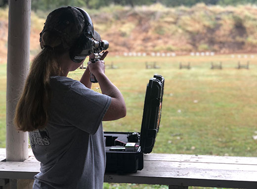Girl shooting pistol toward targets Girl shooting pistol toward targets