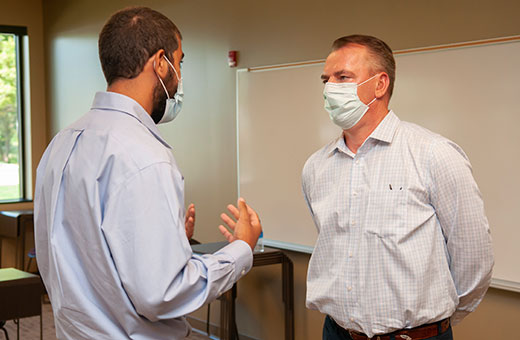 Frank Mitloehner, wearing mask and talking to student