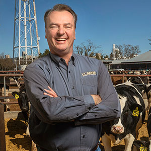 Frank Mitloehner, standing in feedlot with cows in background