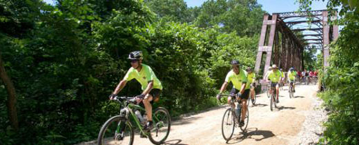 Bikers riding on trail after crossing bridge