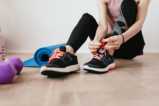 closeup of running shoes, woman tying shoe closeup of running shoes, woman tying shoe