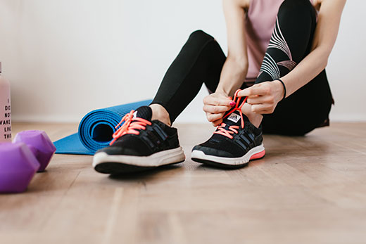 Women sitting down and putting on running shoes