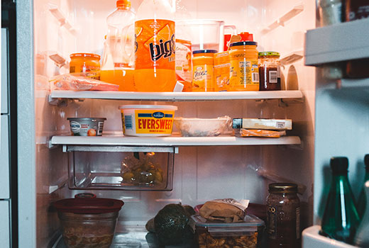 Open refrigerator with food on three shelves