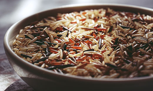 Multi-colored rice in brown bowl
