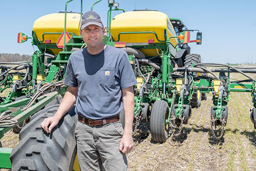 Justin Knopf, farmer standing in front of John Deere tractor Justin Knopf, farmer standing in front of John Deere tractor