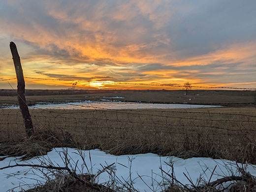 Kansas Scene, farm field with spots of snow at sunset Kansas Scene, farm field with spots of snow at sunset