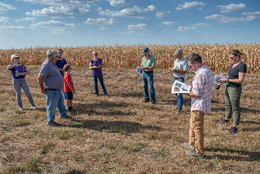 Group standing and talking near farm field