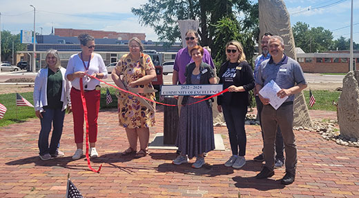 Group of people standing with banner recognizing Community of Excellence Group of people standing with banner recognizing Community of Excellence
