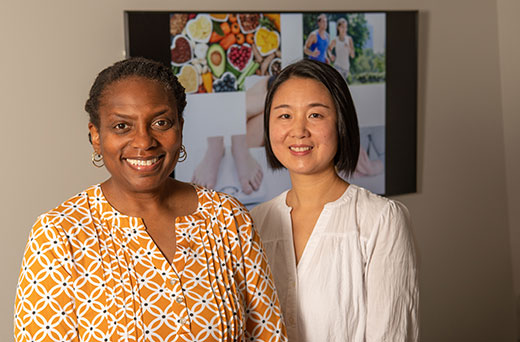 Two women smiling at camera, Tanda Kidd and Yanli Wang Two women smiling at camera, Tanda Kidd and Yanli Wang
