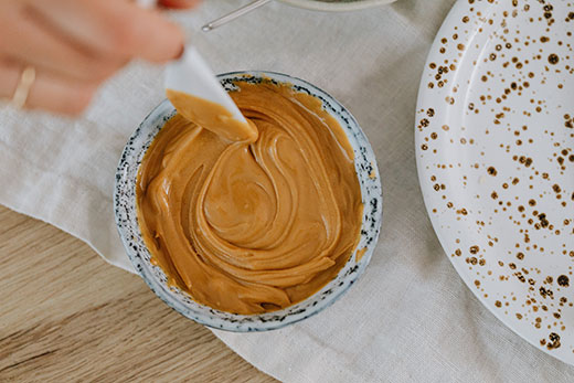 peanut butter and knife in small white bowl