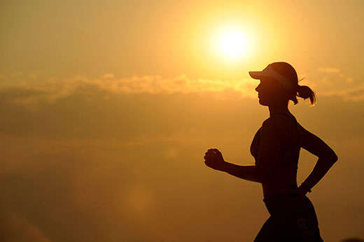 Silhouette of runner against sunrise
