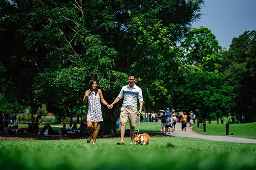 Man and woman walking dog in a park