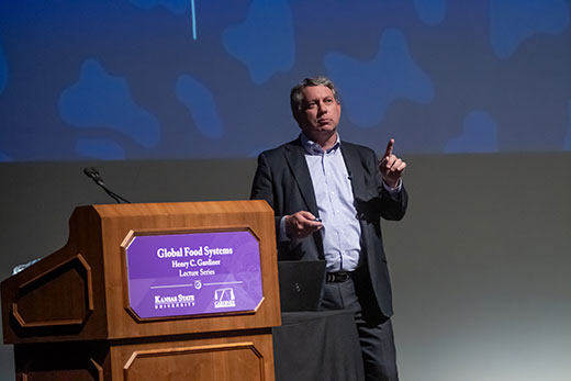 Man in dark suit standing at lectern Man in dark suit standing at lectern