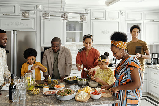 family preparing dinner around kitchen island family preparing dinner around kitchen island