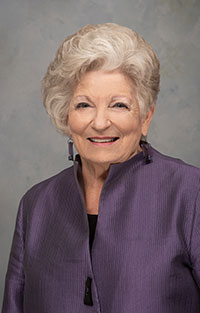 Woman in purple blazer smiling at camera